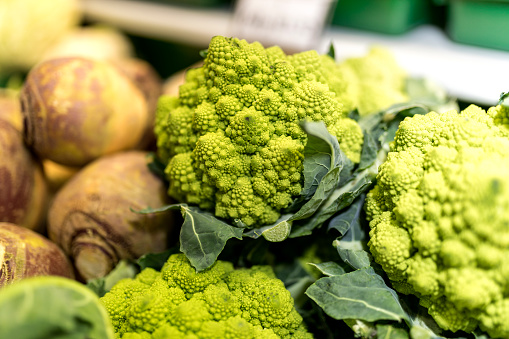 Close up of ripe and vibrant green Romanesco and swede vegetables on a market stall in Yorkshire, United Kingdom