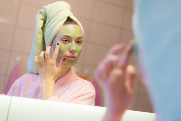 istock Woman putting beauty mask on her face 870562628