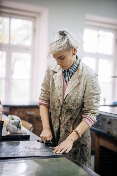 istock Artist filling out mould with ink for etching 870568256