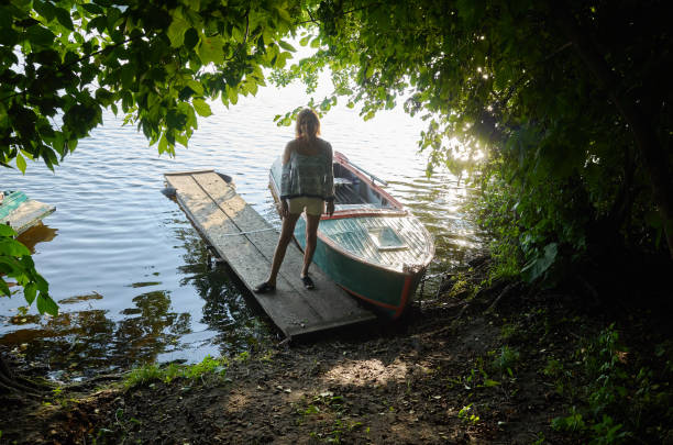 One girl standing on wooden old pier, boat,\n