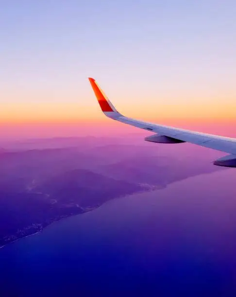 Photo of Sunset view of sky and clouds from window of aircraft flight