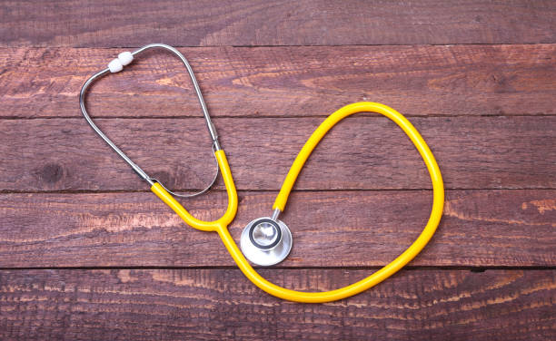 istock Medical stethoscope and tablets isolated on wooden background 870575320