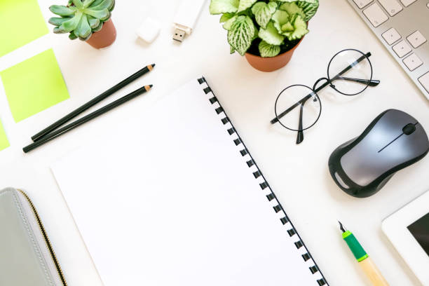 istock Stylish office table desk. Workspace with laptop, diary, succulent on white background. Flat lay, top view. trendy office 870575546