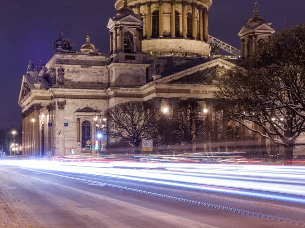 Old historical architecture landmark and touristic spot in Saint Petersburg, Russia: Saint Isaac's Cathedral by night with street in front of it with intense traffic.