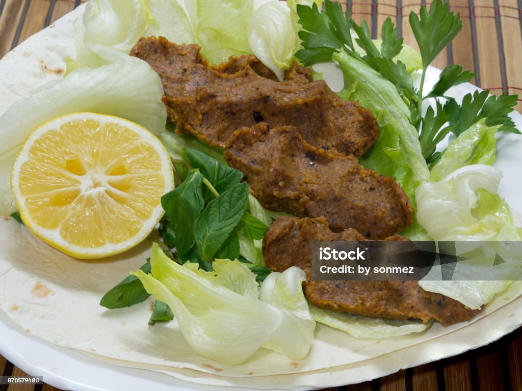 turkish cigkofte and lemon on lettuce, lettuce, parsley, mint Adana Stock Photo