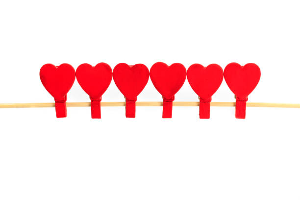 Six peg hearts clipped to a wooden stick isolated on white background