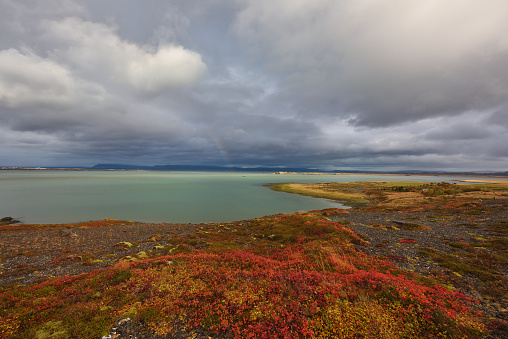 Autumn In Iceland with stormy clouds and rainbow
