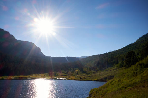 istock Bright sunburst over a Colorado mountain lake 870592296