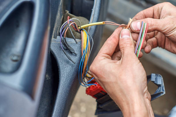 Mechanic connecting electrical cables in car door stock photo