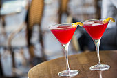 Close-up of two Cosmopolitan martinis on a Paris sidewalk bar patio.