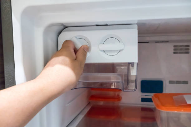 istock Closed up man hand twisting for ice from the ice maker in new refrigerator. 870599186