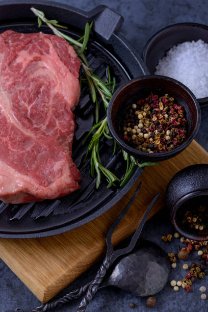 istock Raw beef steak, rosemary and spices in bowl 870599300
