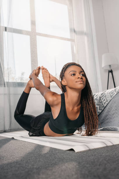 istock woman practicing yoga in bow pose 870602482