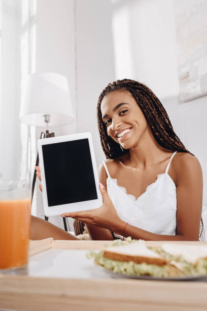istock woman in bed at morning showing tablet 870606464
