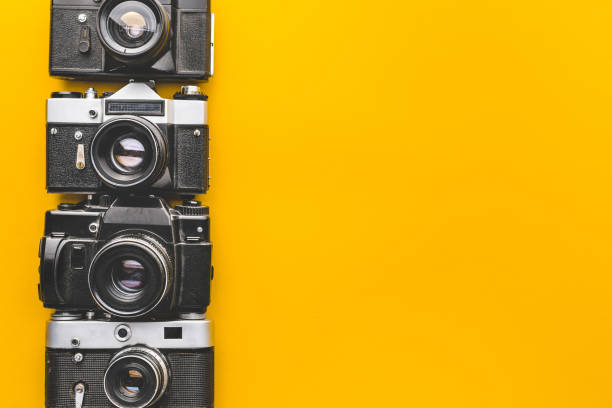 istock Vintage Film Cameras On Yellow Background Surface. Creativity Retro Technology Concept 870617092