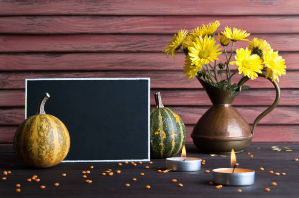 istock Black board, pumpkin and copper jug on brown 870621786