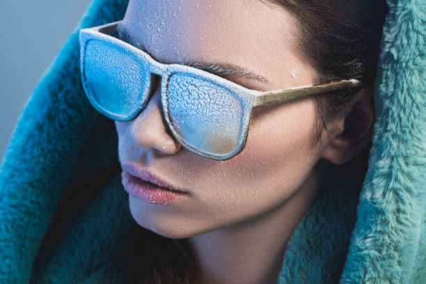 woman with frost on face wearing sunglasses Portrait shot of a young woman in white sunglasses and fur coat, covered in frost bicycle light photos stock pictures, royalty-free photos & images