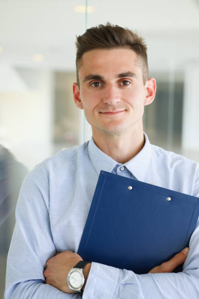 istock Handsome man in shirt and folder stand 870640866