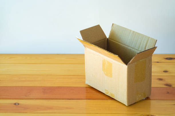 istock Empty opened old brown cardboard box for mock up on the wooden table with copy space. 870641096