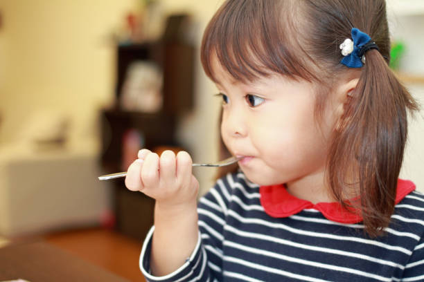 日本の女の子 (3 �歳) の誕生日ケーキを食べる - 2歳から3歳 ストックフォトと画像