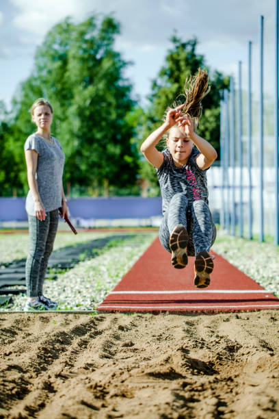 girl teenager trains in long jump stock photo