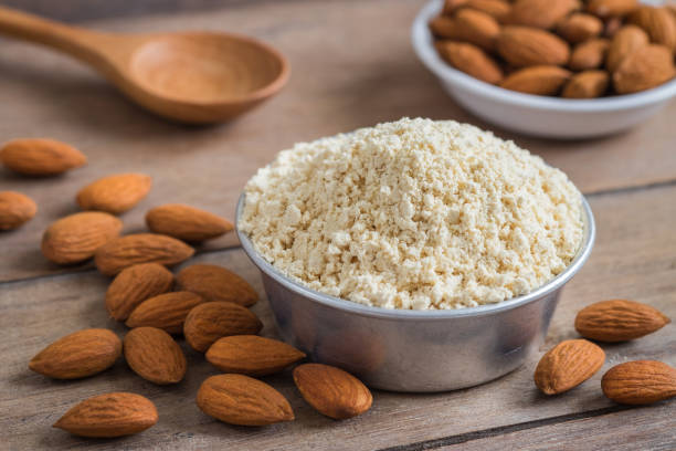 almond flour in bowl and almonds on wooden table - low carb diet food healthy eating raw imagens e fotografias de stock