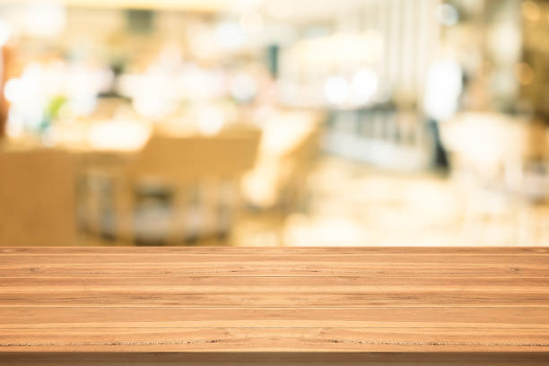 istock Empty wood table top on blurred background at coffee shop,copyspace for montage your products 870694494