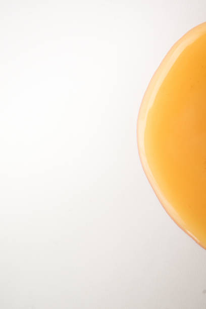 istock Puddle of glossy yellow liquid isolated on white 870701066
