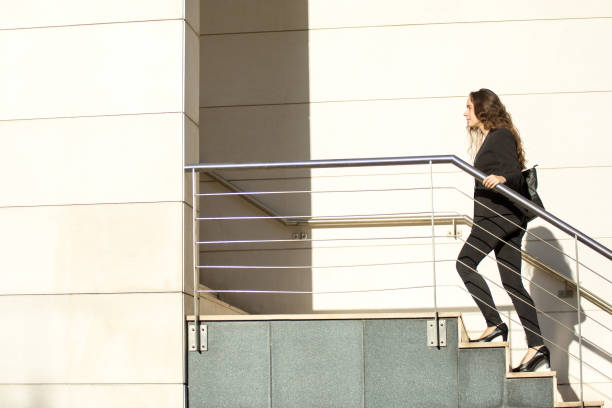 istock Confident young business intern moving up ladder 870704076
