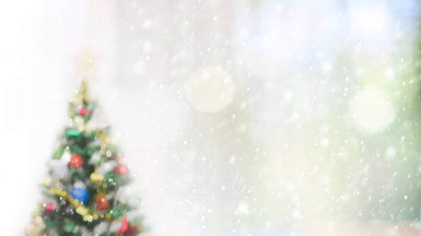 istock Blurred bokeh christmas tree with snowfall background for your text or advertising. 870704684