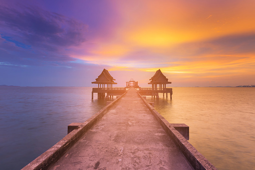 Beauty of sunset seacoast skyline with walkway to abandon temple in ocean, natural landscape background