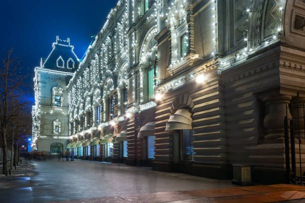 istock Old russian architecture example: Main Department Store (GUM) at the Red Square in Moscow by winter evening with Christmas illumination with people walking. 870711232