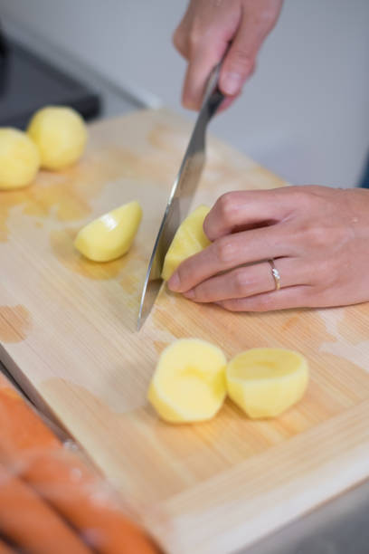 istock housewife cutting potatoes in kitchen 870711634