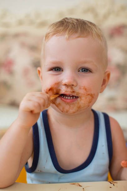 istock Content Dirty-faced Boy Biting Ice-Cream Stick 870711956