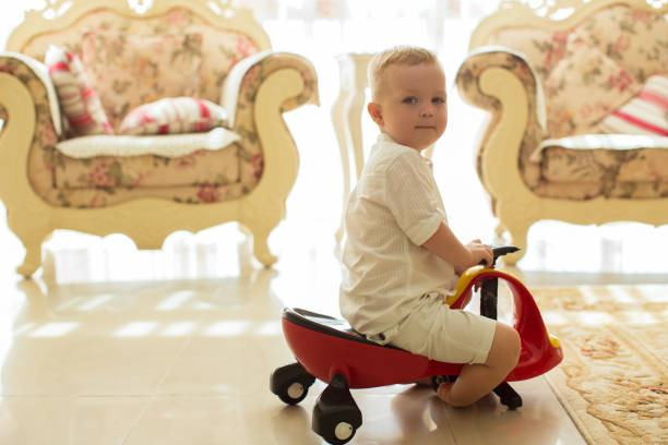 istock Little Boy Riding Toy on Wheels at Home 870712026
