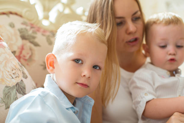 istock Mother Sitting on Sofa at Home with Two Sons 870714216