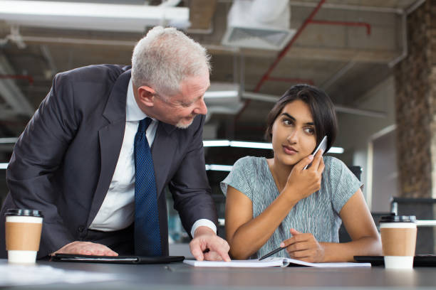 istock Smiling Senior Boss Instructing Female Assistant 870714736