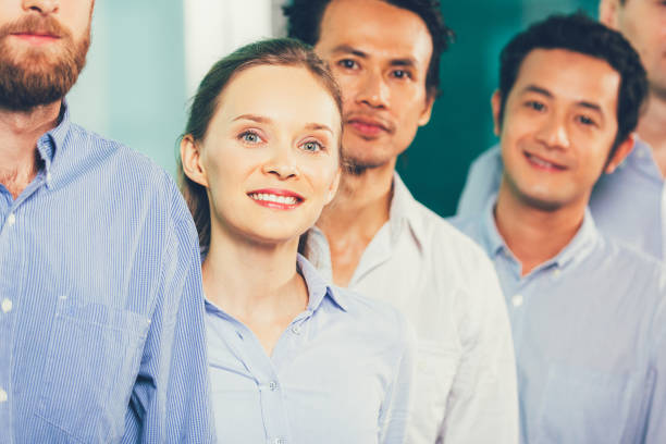 istock Cheerful businesswoman standing in row 870715872