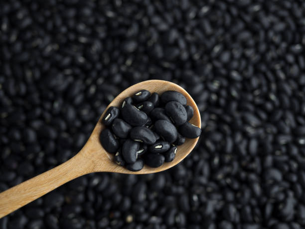 istock black beans in a wooden spoon with black beans background 870722048
