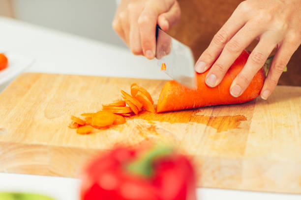 istock Close-up of hands chopping carrot on cutting board 870722122