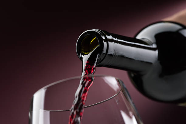 pouring red wine into a wineglass - wineglass red wine wine liquid imagens e fotografias de stock