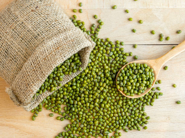 istock Mung beans(green beans) in a sack, on wood background 870723630