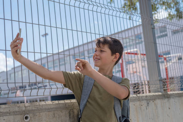 istock Student resting outside a school and playing with a mobile phone 870723892