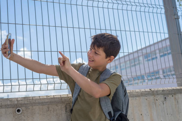 istock Student resting outside a school and playing with a mobile phone 870723946