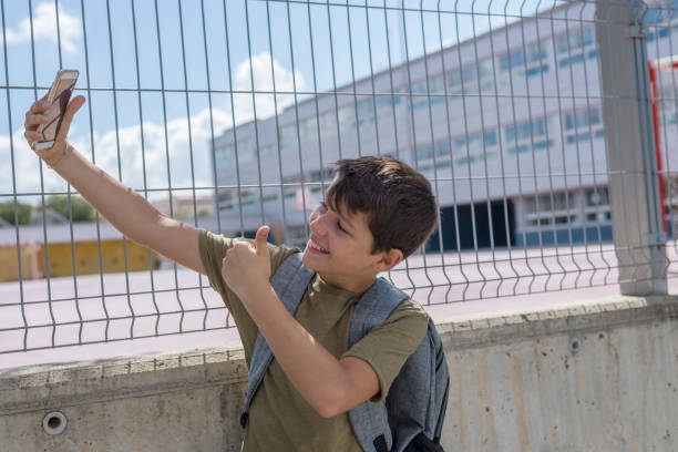 istock Student resting outside a school and playing with a mobile phone 870726022