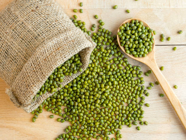 istock Mung beans(green beans) in a sack, on wood background 870726340