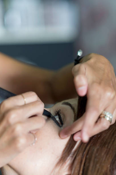 istock Young makeup artist doing makeover to pretty model 870729246