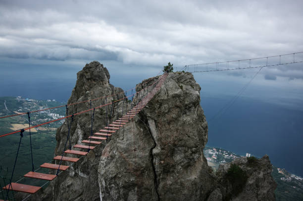 istock Hanging bridge in steep rocks 870729300