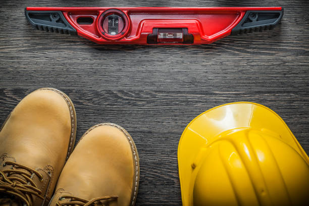 istock Construction level hard hat safety waterproof boots on wooden bo 870734948