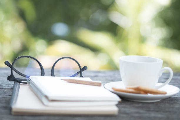 istock Open empty notebook with pencil, glasses, black coffee and biscuits. Blur picture 870738768